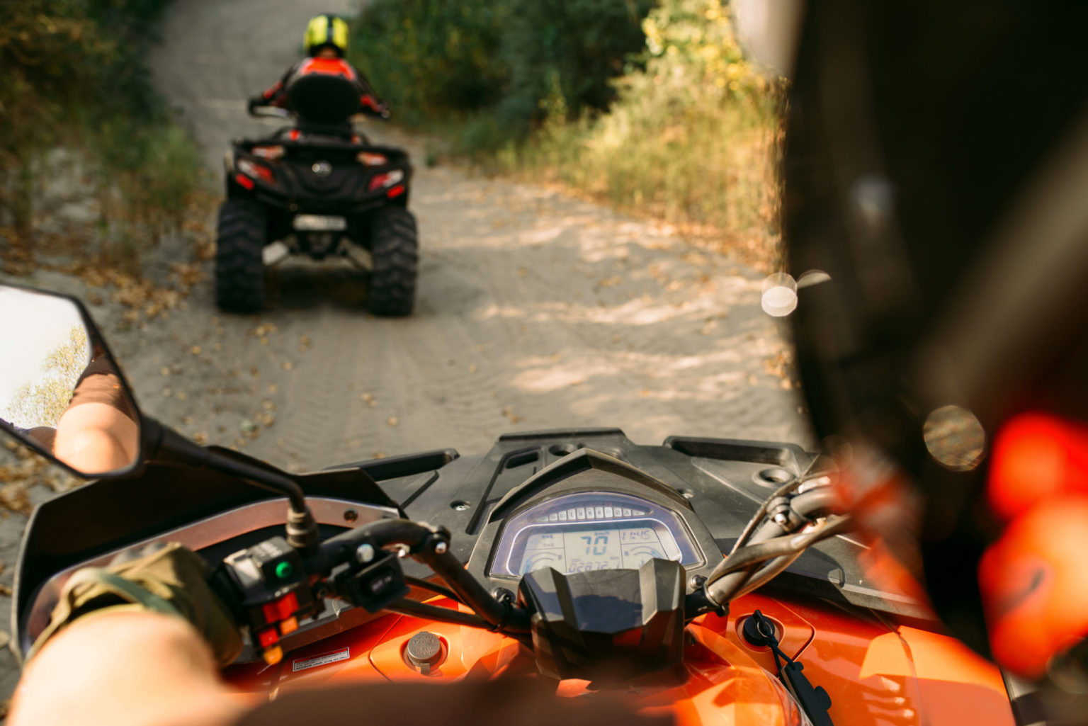 a group of people riding motorcycles on a dirt road