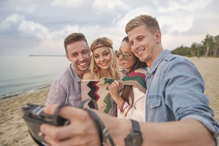 a group of people posing for a photo on a beach