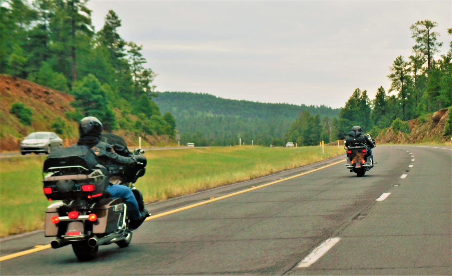 a group of motorcycles driving down a road